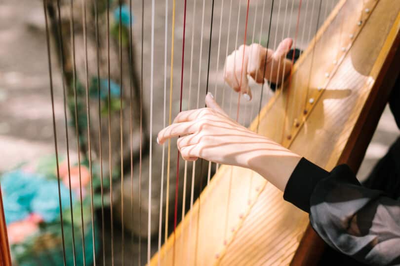Hands of the woman playing a harp. Symphonic orchestra. Harpist close up.