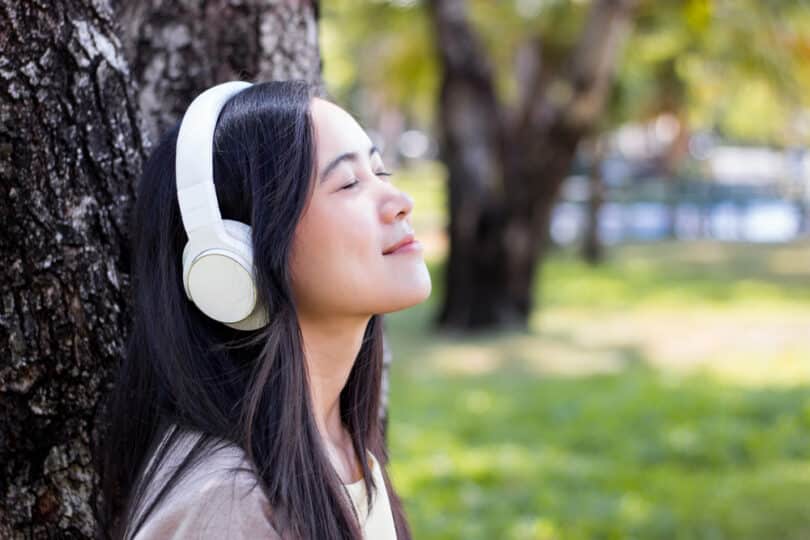 Beautiful asian woman listen to music with white headphone in na