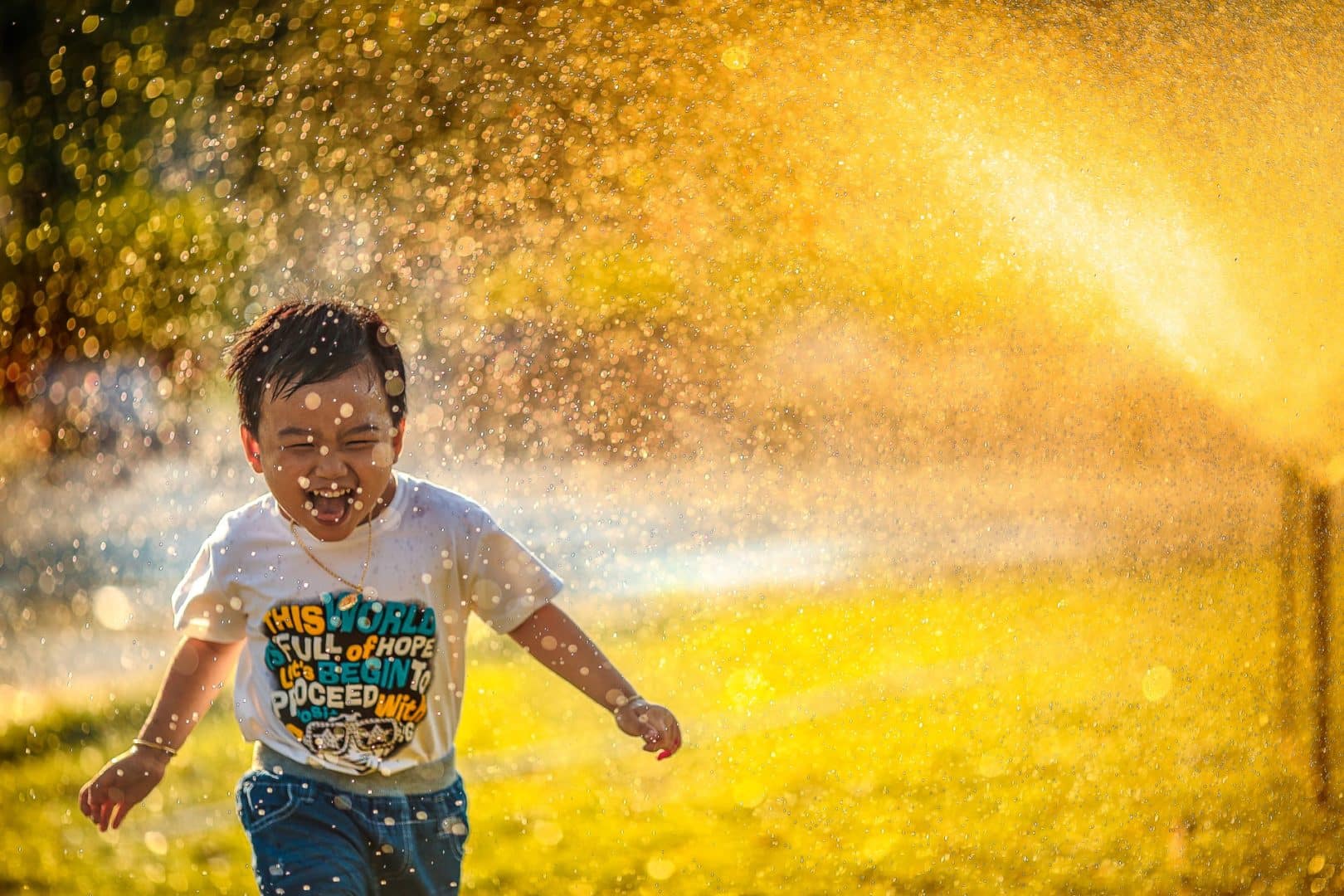 happy boy in sprinklers